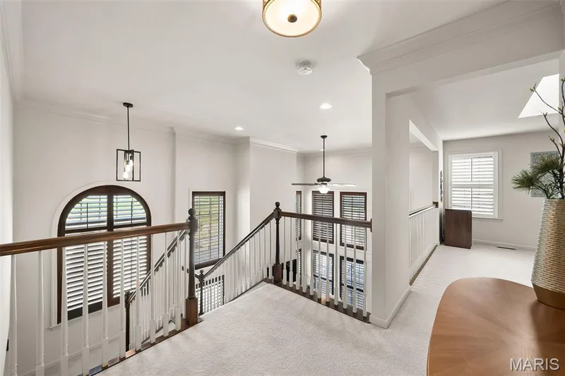 Upper level landing featuring light-toned carpet, a skylight, and white plantation shutters — 2700 Grover Crossing Drive, Wildwood, MO 63040