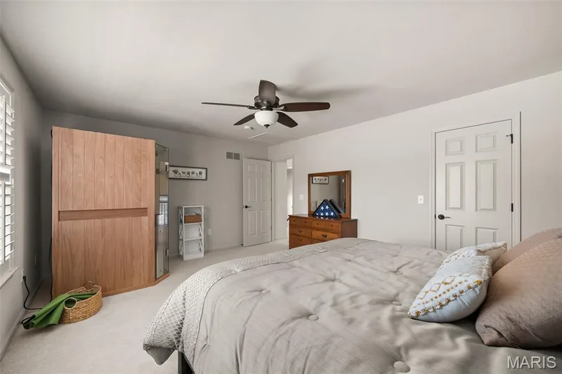 Neutral wall color, ceiling fan, white six-panel doors, plantation shutters, and carpeted flooring — 2700 Grover Crossing Drive, Wildwood, MO 63040