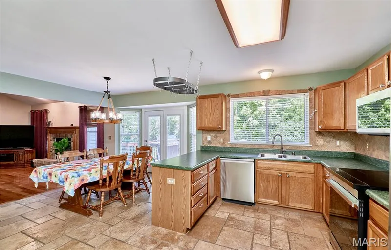 Kitchen featuring wood cabinetry, stainless steel appliances, and a tile backsplash — 3641 Wind Chime Lane, St Charles, MO 63301