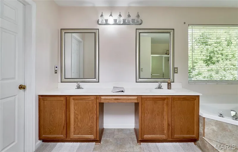 Dual vanity with wood-finish cabinetry and white countertops — 3641 Wind Chime Lane, St Charles, MO 63301
