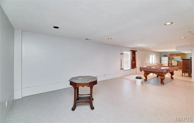Spacious lower-level room featuring light-colored flooring, recessed lighting, and white painted walls — 3641 Wind Chime Lane, St Charles, MO 63301