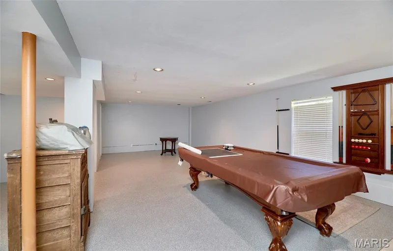 Recessed lighting illuminates this expansive recreation space featuring light-colored carpeting — 3641 Wind Chime Lane, St Charles, MO 63301