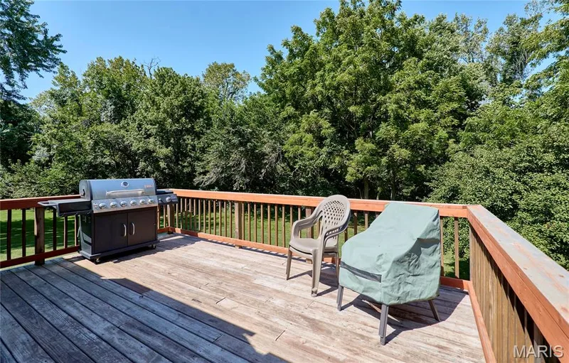 Expansive composite deck featuring multiple levels, wood-finish decking, and black metal railings with cable detailing — 3641 Wind Chime Lane, St Charles, MO 63301