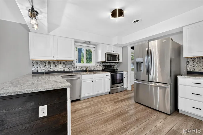 Stainless Steal Appliances, luxury vinyl plank floor, decorative ceramic tile backsplash, granite counter top and very cool lighting. — 120 S Duchesne Drive, St Charles, MO 63301