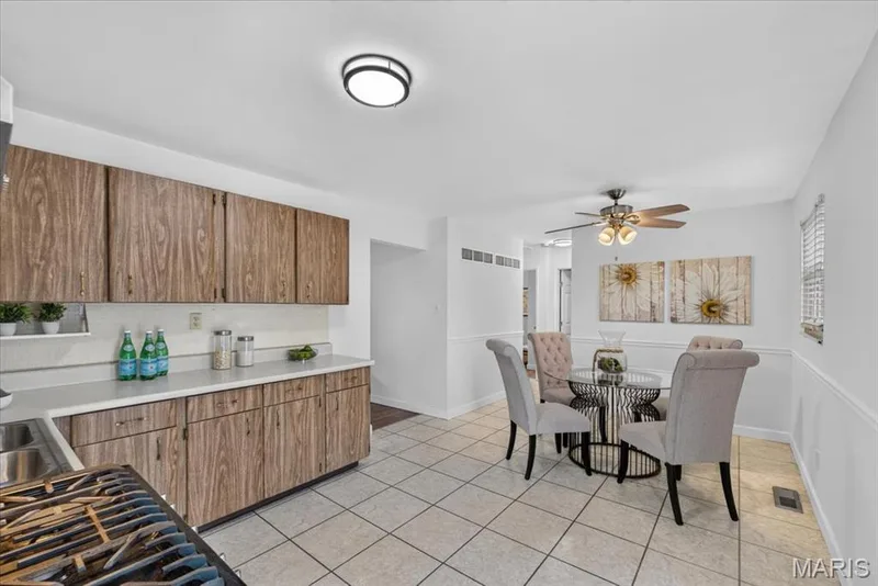 Kitchen with tile flooring, wood-finish cabinetry, and a ceiling fan — 11 Toelle Drive, St Charles, MO 63304