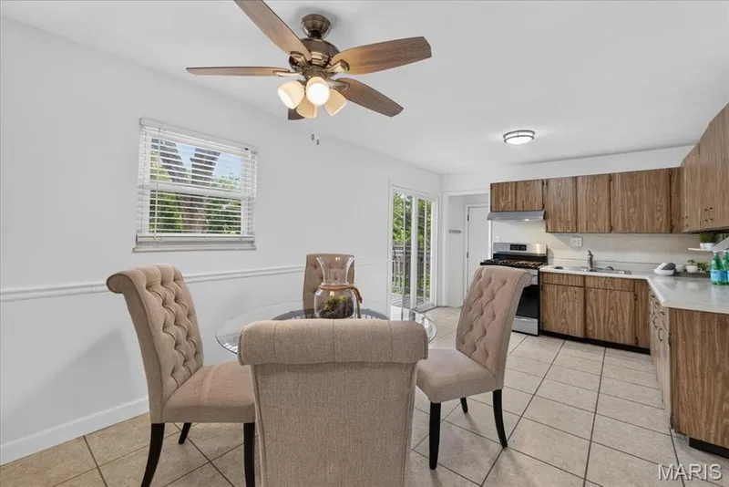 Kitchen featuring wood-finish cabinetry, stainless steel appliances, and a ceiling fan with integrated lighting — 11 Toelle Drive, St Charles, MO 63304