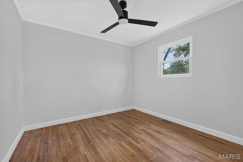 Hardwood flooring, crisp white trim, single window, contemporary ceiling fan, light gray wall finish — 11 Toelle Drive, St Charles, MO 63304