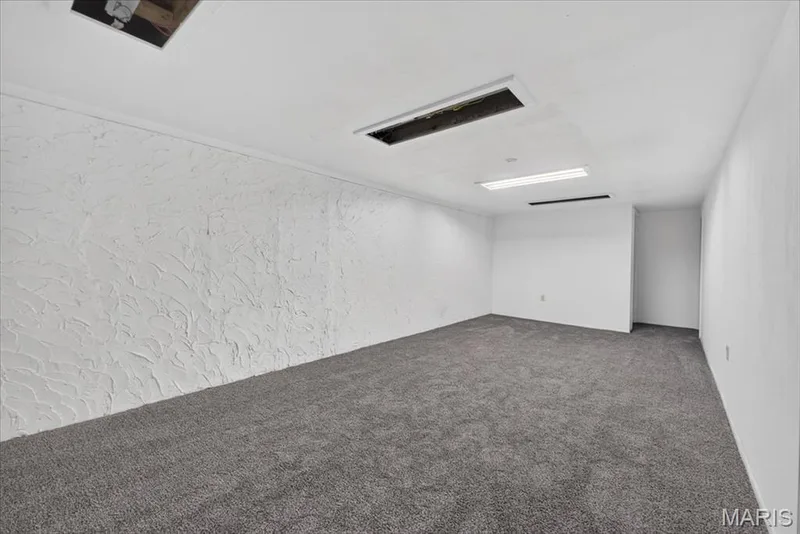 Expansive room featuring textured wall finishes, recessed lighting, and grey carpeting — 11 Toelle Drive, St Charles, MO 63304