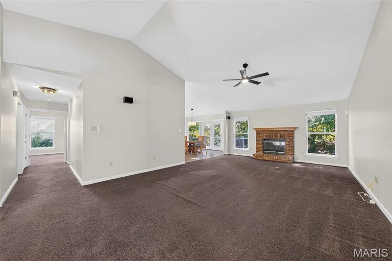 Vaulted ceiling, brick-surround fireplace, ceiling fan, and French doors — 155 Snake River Drive, Dardenne Prairie, MO 63368