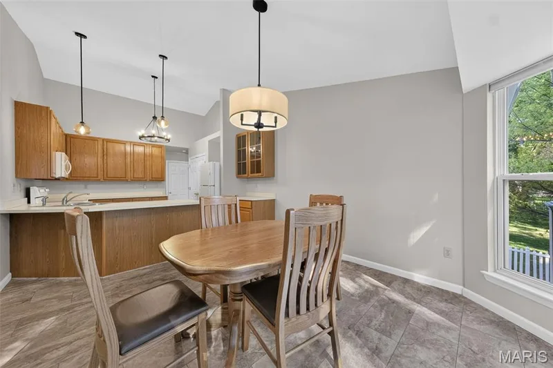 Vaulted ceilings with pendant lighting, wood cabinetry, solid surface countertops, and tiled flooring — 155 Snake River Drive, Dardenne Prairie, MO 63368