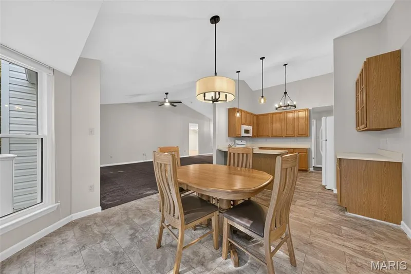 Vaulted ceilings, wood-finish cabinetry, tile flooring, pendant lighting, and a ceiling fan — 155 Snake River Drive, Dardenne Prairie, MO 63368