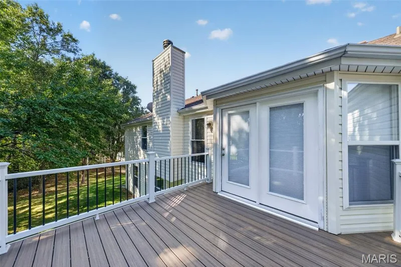 Expansive outdoor deck featuring wood-finish flooring and white railing with black balusters — 155 Snake River Drive, Dardenne Prairie, MO 63368