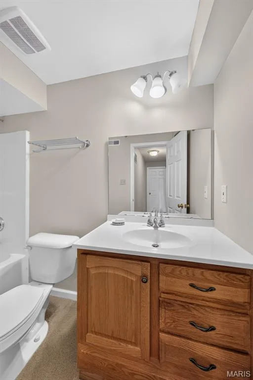 Wood-finish vanity with integrated sink, chrome faucet, and ample storage — 155 Snake River Drive, Dardenne Prairie, MO 63368