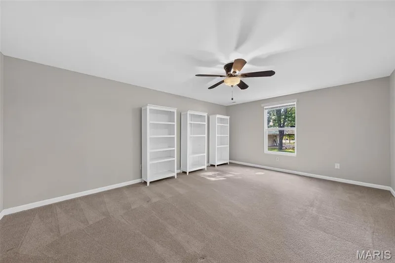 Neutral tone walls, ceiling fan with integrated lighting, carpeted flooring, and a single window with blinds — 155 Snake River Drive, Dardenne Prairie, MO 63368