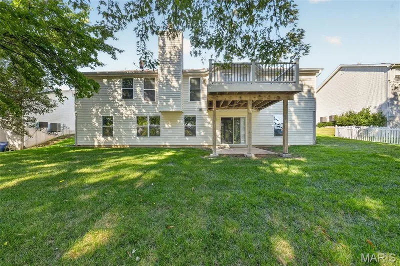 Expansive green space featuring a multi-level deck, a concrete patio, and a privacy fence — 155 Snake River Drive, Dardenne Prairie, MO 63368