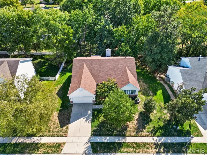 Gable roofline residence with an attached garage, concrete driveway, and mature landscaping — 155 Snake River Drive, Dardenne Prairie, MO 63368