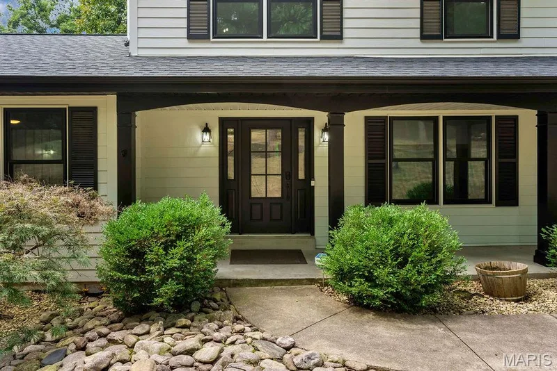 Contrasting against the white siding, the black exterior details really pop! Newer triple-paned windows installed in 2024!!! — 2 Patrick Lane, Defiance, MO 63341