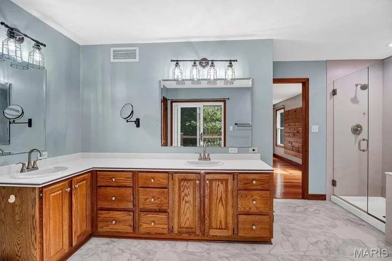 Dual sinks and plenty of storage with lots of cabinets and a full-size linen closet. — 2 Patrick Lane, Defiance, MO 63341