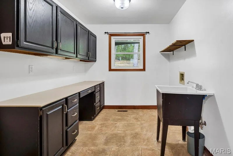 Rounding out the main level is the main floor laundry! It is off of the side-entry garage & kitchen and features lots of cabinets, a coat closet & wash sink! — 2 Patrick Lane, Defiance, MO 63341