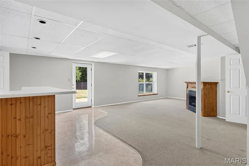 Lower level family room with door to backyard and bar — 7235 Picasso Drive, Dardenne Prairie, MO 63368