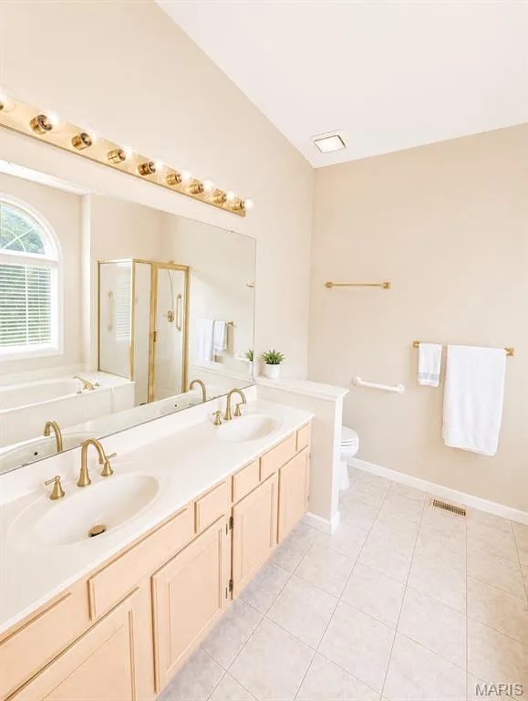 Double vanity with integrated sinks, brass-finish fixtures, and ample cabinet storage — 1605 Ridge Bend Drive, Glencoe, MO 63038