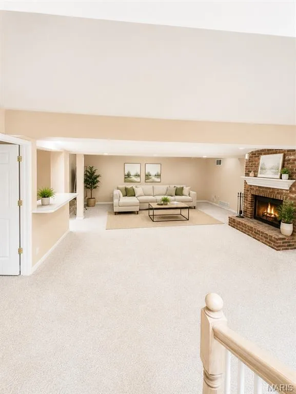 Expansive open-concept downstairs living space featuring neutral carpeting, cream-toned walls, and abundant natural light from multiple windows — 1605 Ridge Bend Drive, Glencoe, MO 63038