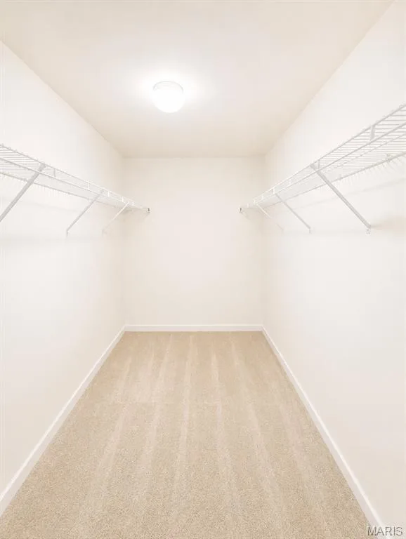 Spacious walk-in closet featuring dual wire shelving systems, wood-finish flooring, recessed ceiling lighting, and bright, neutral walls providing ample storage and organization options — 1605 Ridge Bend Drive, Glencoe, MO 63038