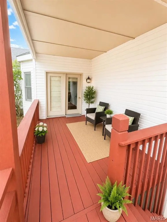 Covered patio with retractable shade awning overlooking a composite deck featuring rich terracotta railings and planters — 1605 Ridge Bend Drive, Glencoe, MO 63038