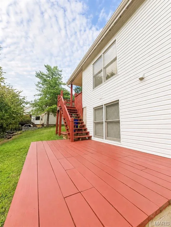 Exterior deck with red-painted wood planks, white horizontal siding, and multi-pane windows — 1605 Ridge Bend Drive, Glencoe, MO 63038