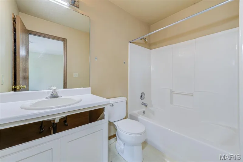 White vanity with an integrated sink, polished chrome faucet, and full-width mirror — 4306 Sherman Park Drive #10F, St Charles, MO 63303