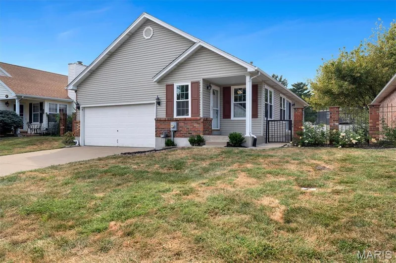 Light-colored siding exterior with brick accents and a covered front porch — 857 Du Pre Court, St Peters, MO 63376