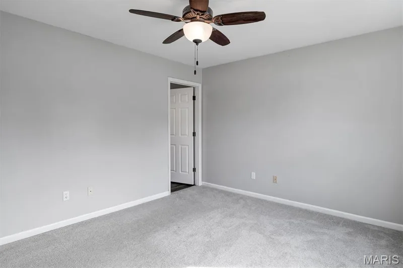 Neutral wall tones, ceiling fan with integrated lighting, broadloom carpeting, and a paneled door — 857 Du Pre Court, St Peters, MO 63376