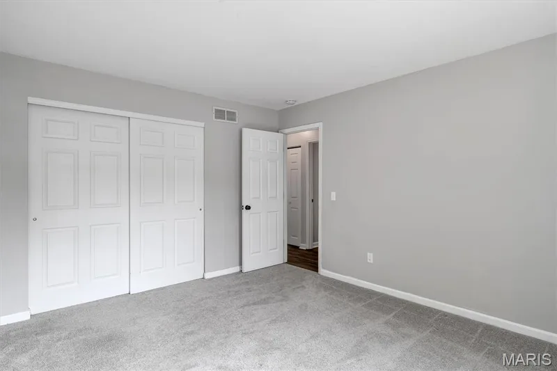 Neutral gray wall finishes, light gray carpeting, white trim, and white paneled doors — 857 Du Pre Court, St Peters, MO 63376