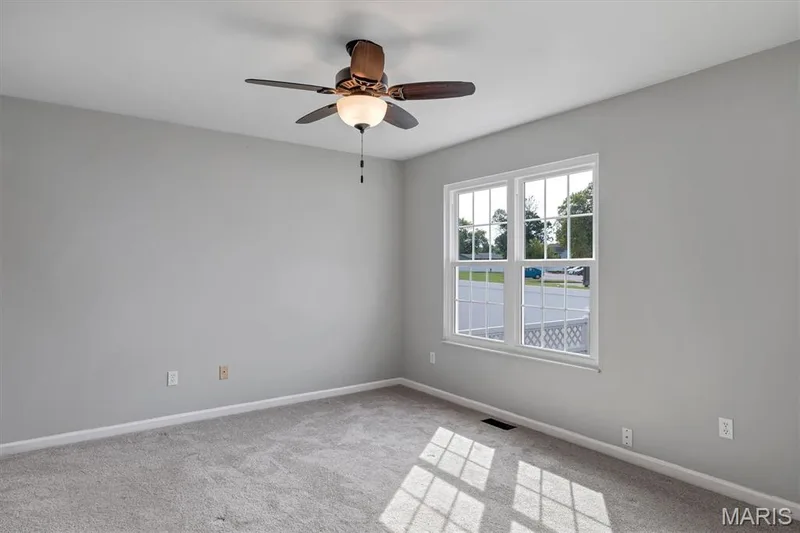 Ceiling fan with integrated lighting, double-hung windows, light gray wall finish, and carpeted flooring — 857 Du Pre Court, St Peters, MO 63376