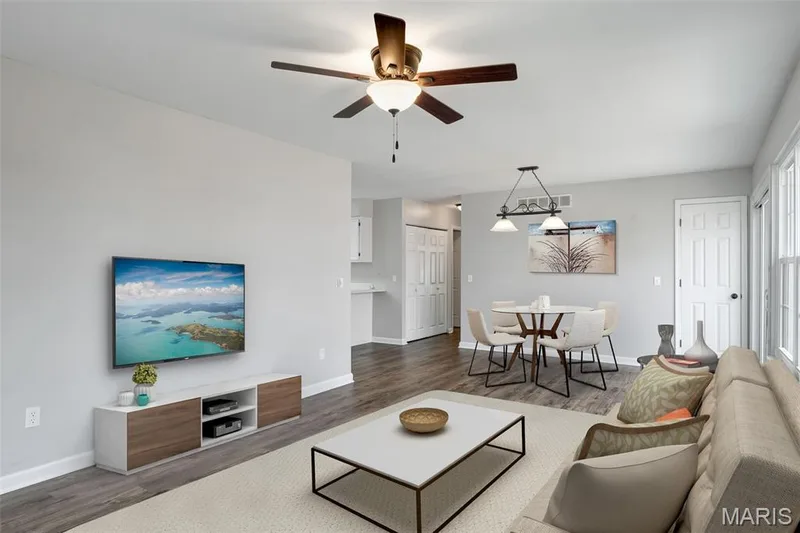 Wood-finish flooring, ceiling fan, white paneled doors, large windows, and a dining area with pendant lighting — 857 Du Pre Court, St Peters, MO 63376
