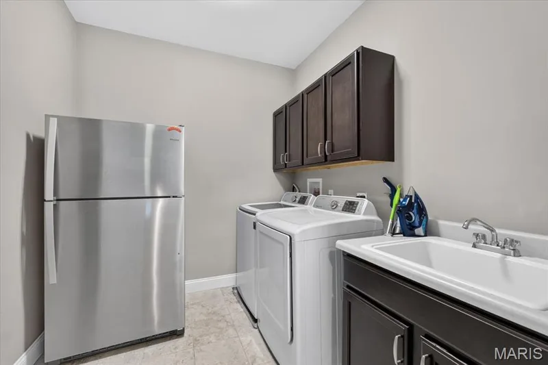 Main-floor laundry room with utility sink and cabinetry — 1307 Homestead Heights Drive, Wildwood, MO 63005