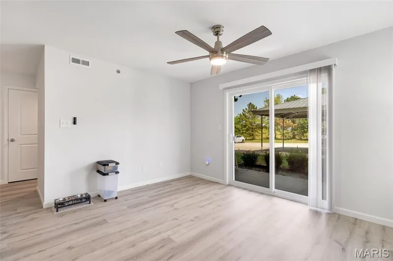 The open-concept living area flows effortlessly outward, creating a serene indoor-outdoor connection through expansive sliding glass doors. — 4101 Spring Creek Lane, O'Fallon, MO 63368