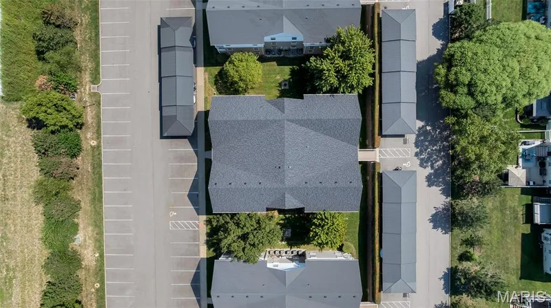 A bird's-eye aerial perspective showcases the abundant resident parking and convenient covered carports set against lush greenery. — 4101 Spring Creek Lane, O'Fallon, MO 63368