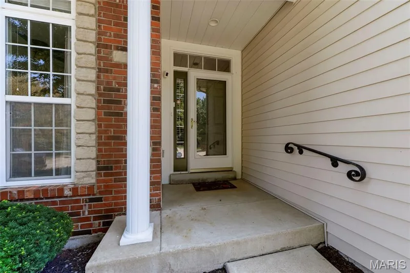 Sidelight, transom window at entry.  Sturdy Iron Handrail at step — 18 Eagle Bluff Lane, St Charles, MO 63303