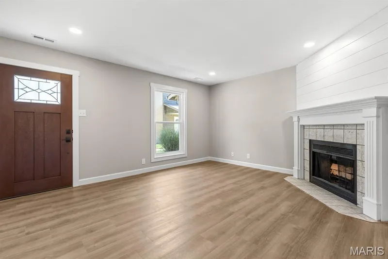 Spacious living room and wood burning fireplace. New luxury vinyl plank flooring & fresh custom paint — 39 Park Charles Boulevard S #D, St Peters, MO 63376