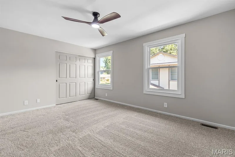 View 2 of primary bedroom features new double hung windows with wood trim — 39 Park Charles Boulevard S #D, St Peters, MO 63376