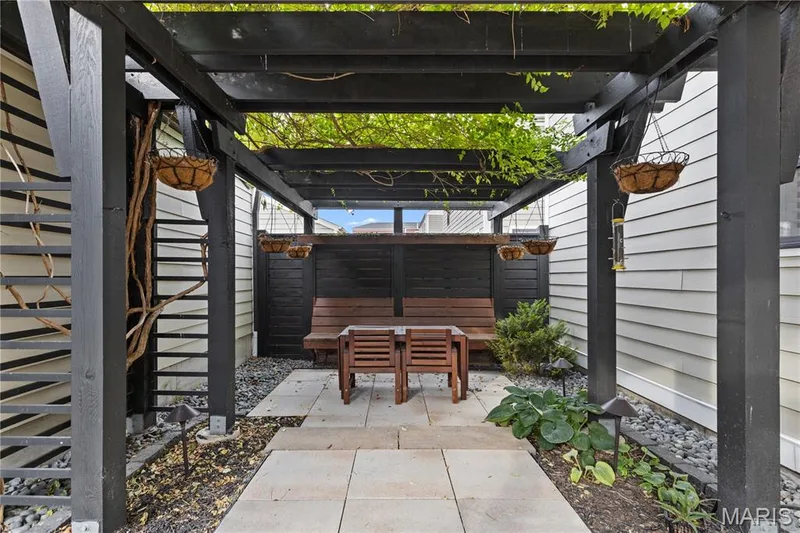 Pergola structure with a stone patio, gravel ground cover, and integrated landscaping — 3222 Starkville Street, St Charles, MO 63301