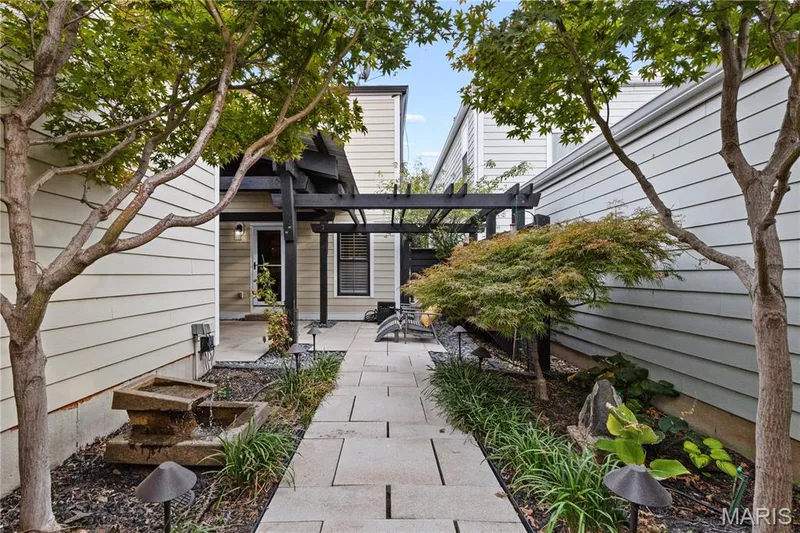 Paved walkway leading to an outdoor patio with a black pergola — 3222 Starkville Street, St Charles, MO 63301