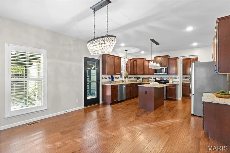Kitchen and dining area featuring wood-finish flooring, recessed lighting, and a kitchen island with stone countertops — 3222 Starkville Street, St Charles, MO 63301