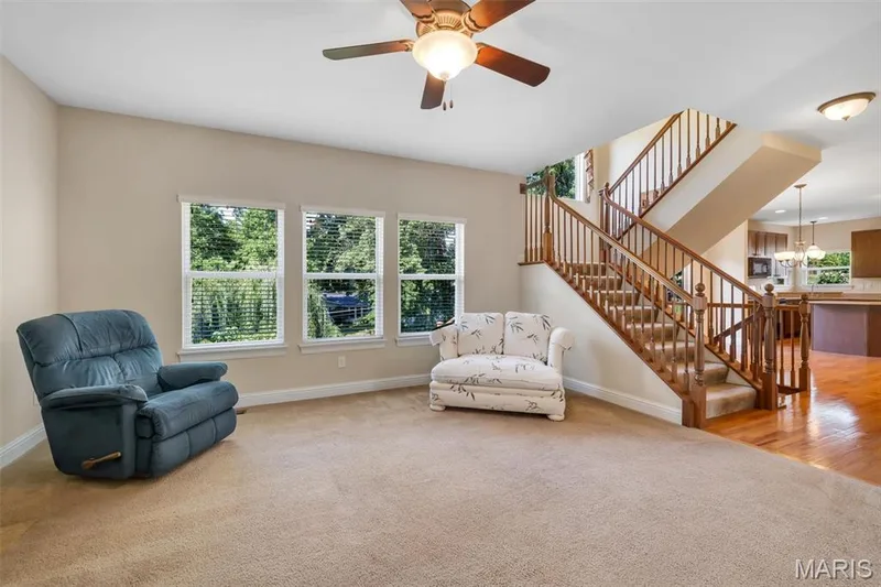 Multiple windows, wood staircase with carpeted treads, wood flooring, ceiling fan with integrated lighting, and recessed lighting — 1016 Gardenbridge Place, St Charles, MO 63303