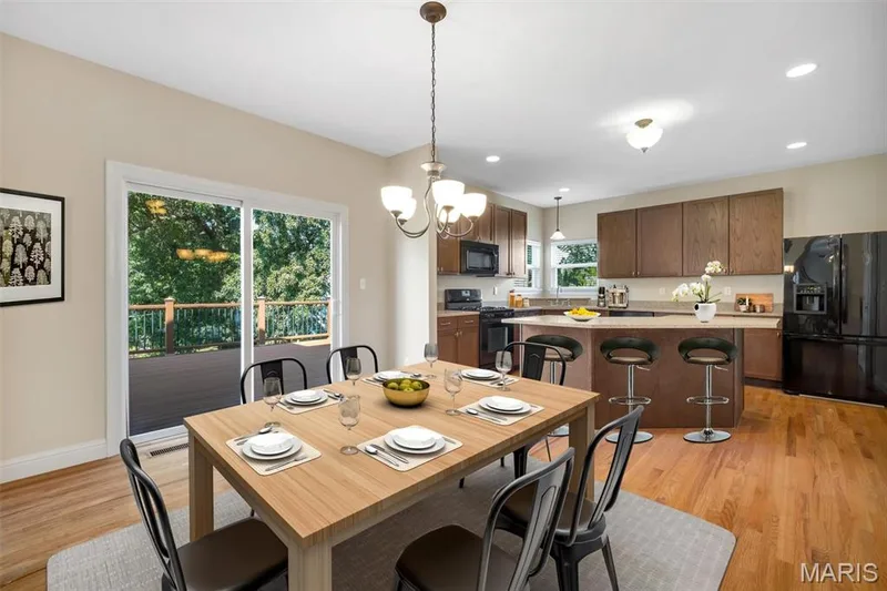 Hardwood flooring throughout, kitchen with wood-finish cabinetry, built-in appliances, and a breakfast bar — 1016 Gardenbridge Place, St Charles, MO 63303