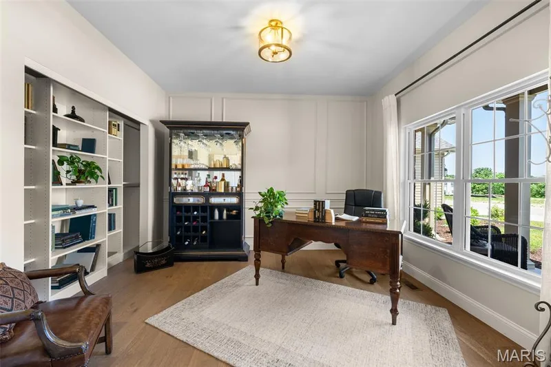 Recessed built-in shelving, wood-finish flooring, accent wall paneling, large multi-pane windows, and a flush mount light fixture — 193 Santa Elena Drive, Wentzville, MO 63385