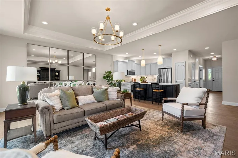 Open-concept living space featuring wood-finish flooring, recessed lighting, and a tray ceiling — 193 Santa Elena Drive, Wentzville, MO 63385