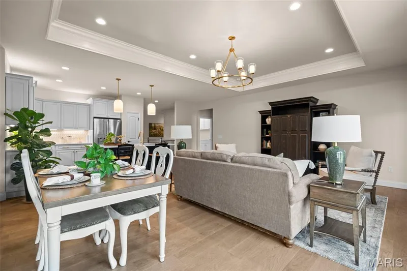 Tray ceiling with crown molding, recessed lighting, wood-finish flooring, light gray kitchen cabinetry, and stainless steel appliances — 193 Santa Elena Drive, Wentzville, MO 63385