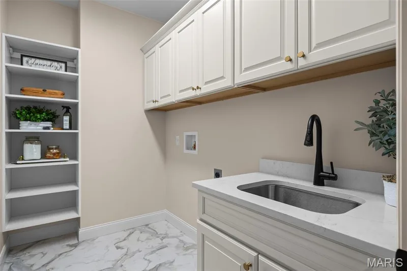 Built-in shelving, white shaker cabinetry with brass hardware, undermount sink, matte black faucet, and stone-finish flooring — 193 Santa Elena Drive, Wentzville, MO 63385